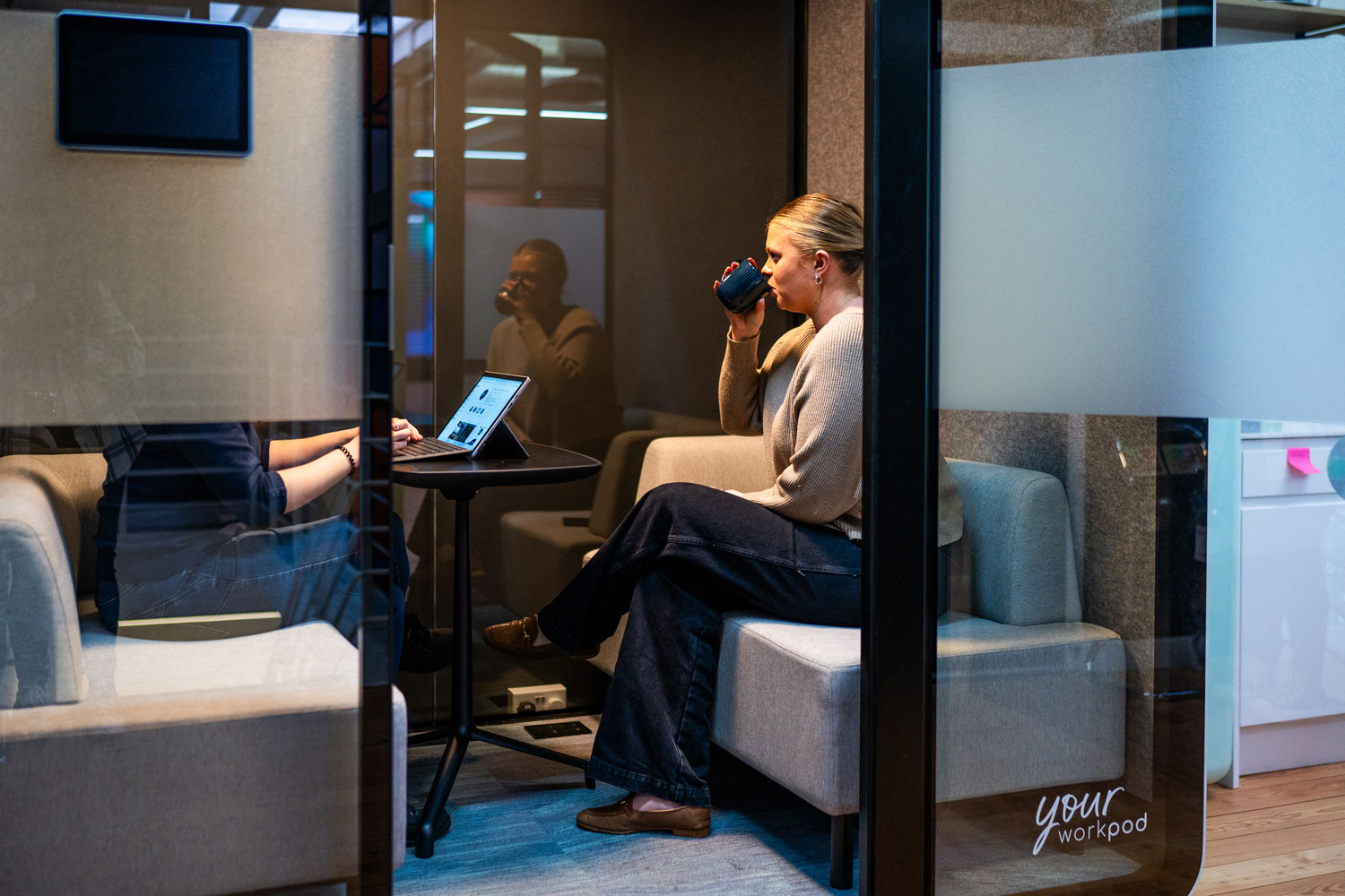 Two people inside a meeting pod.