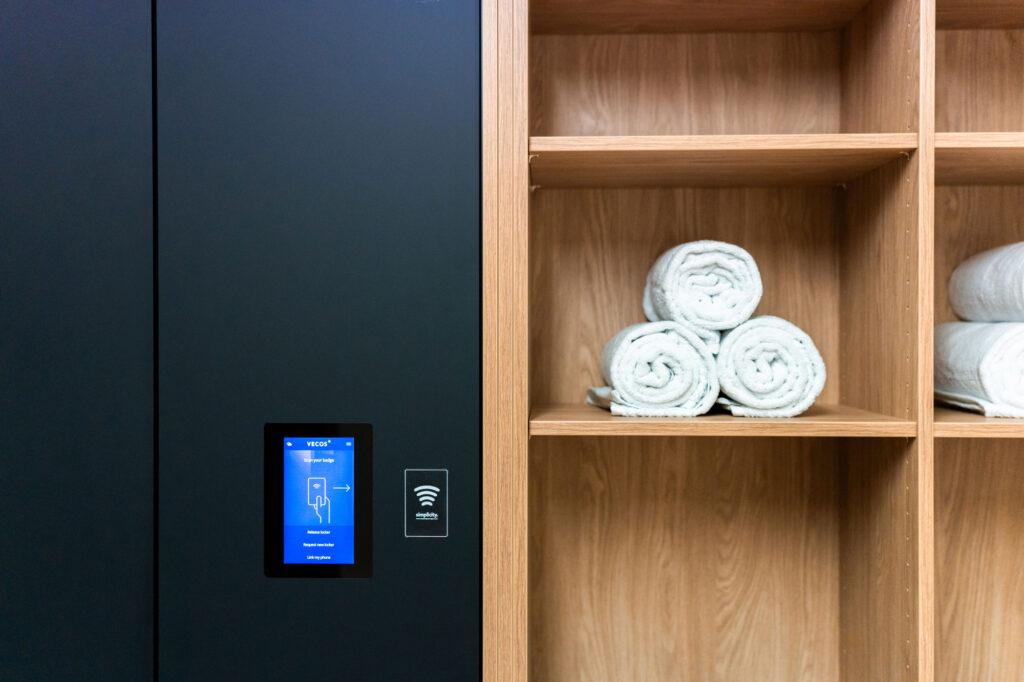 Smart lockers in a changing room with integrated towel storage.
