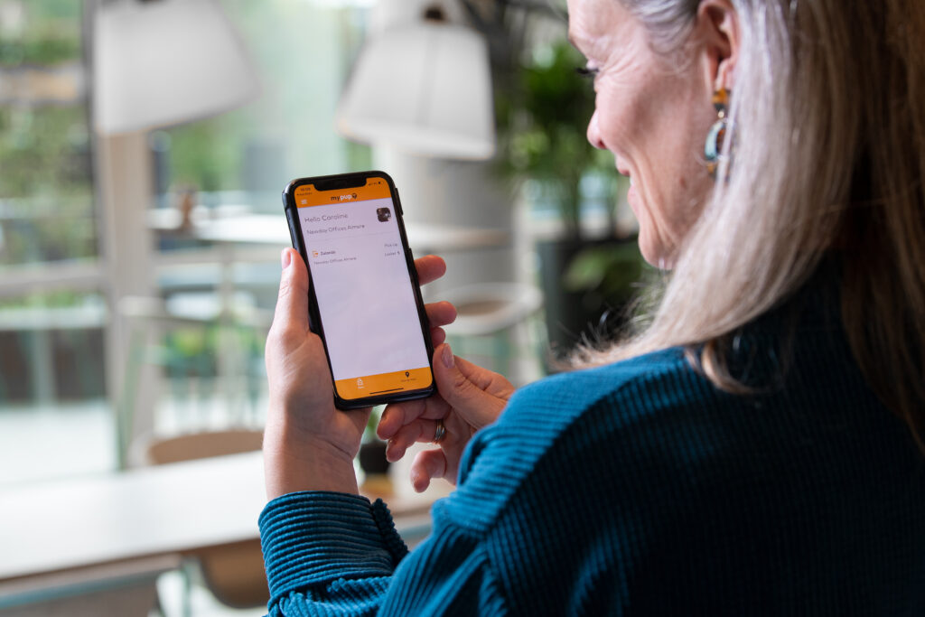 Person using a mobile app to manage their parcel locker at work.