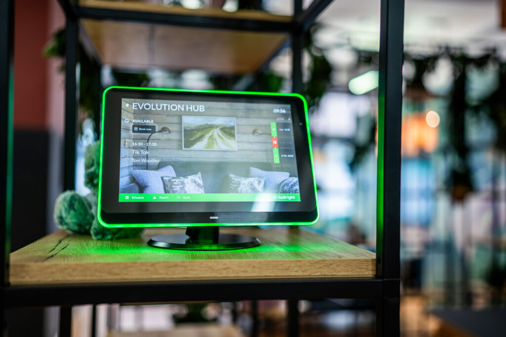 Room booking management software on a tablet on modular shelving.