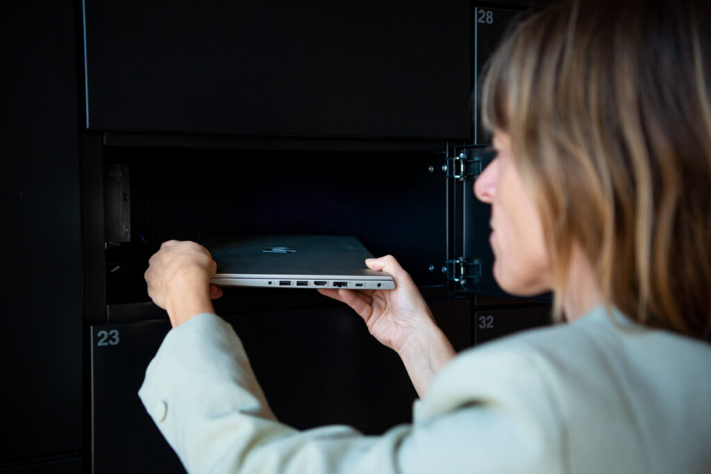 Person collecting a laptop from an office smart locker for parcel and IT asset management.